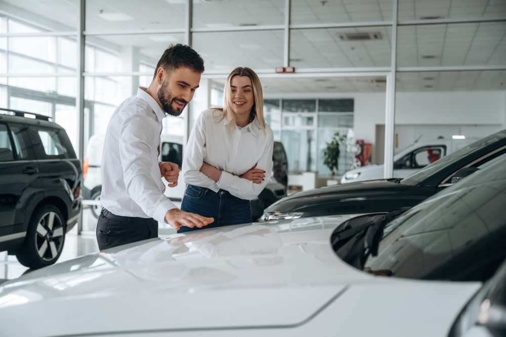 Comprar coche ocasión Comerciales hablan mientras muestran un coche de ocasión