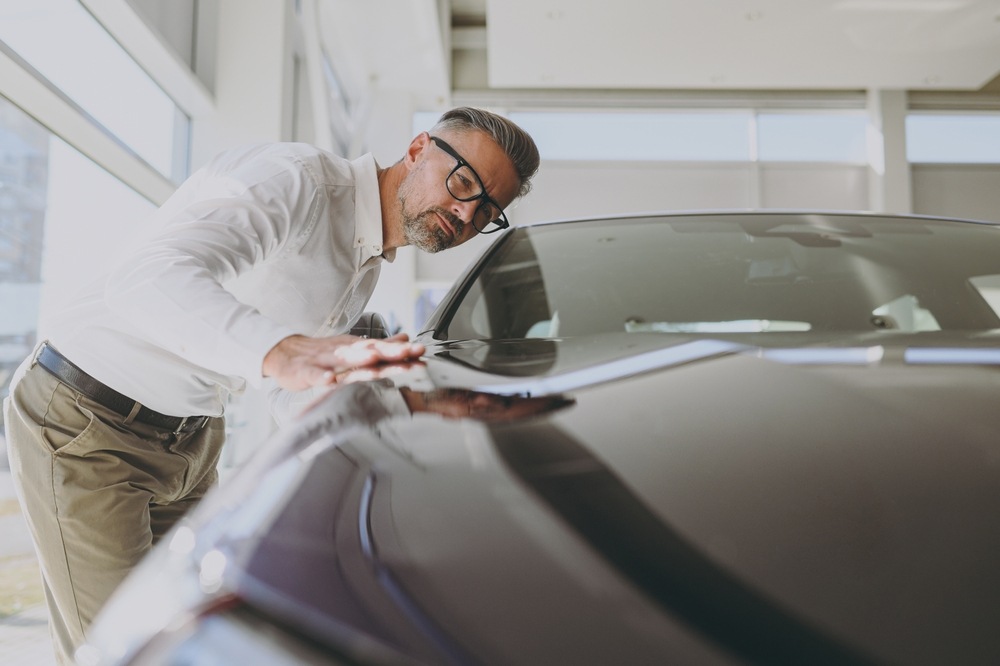 hombre revisa un coche de segunda mano