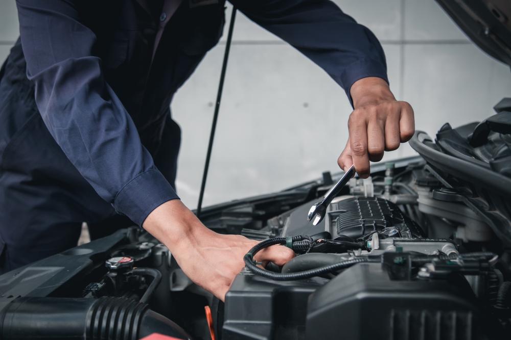 Mecánico revisando el motor de un coche de segunda mano en taller