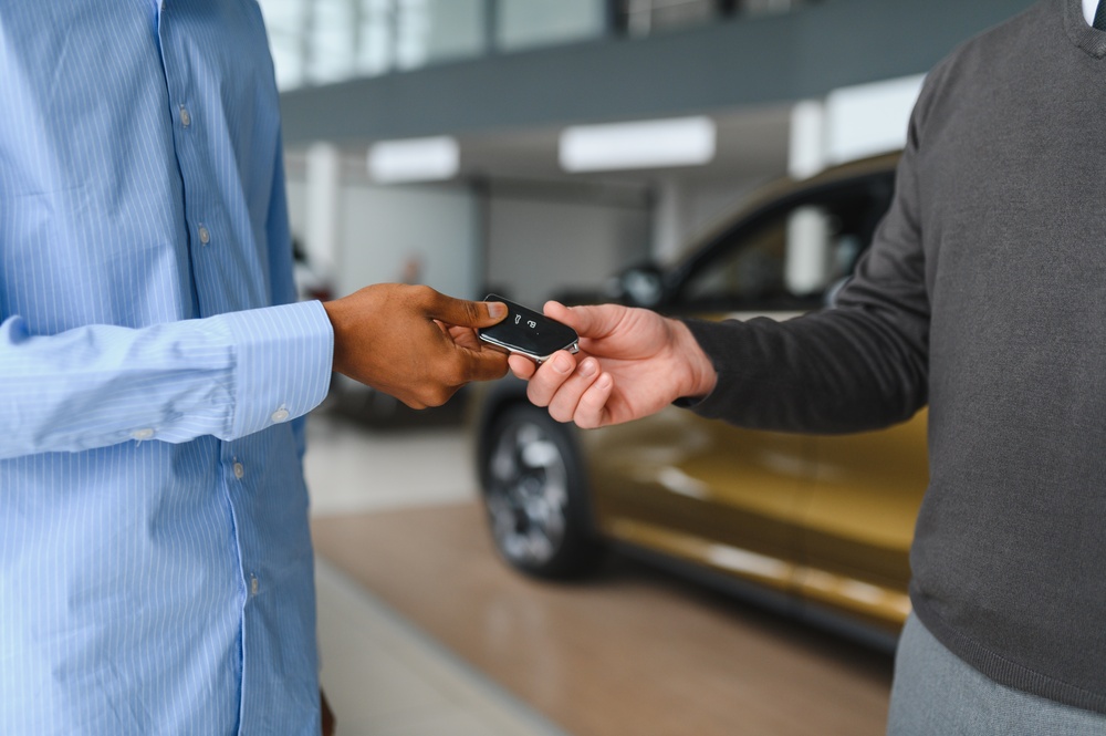 Salesman,Is,Giving,Keys,For,New,Car,To,Man.,The Entrega de llaves durante la venta de un coche en Madrid
